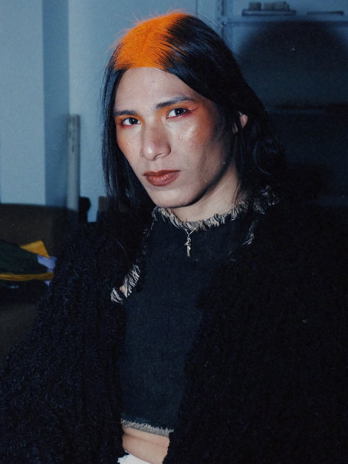 Retrato editorial de una modelo con un mechón de cabello naranja.
