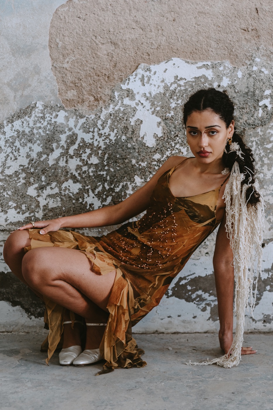 Retrato editorial de una modelo con vestido dorado.